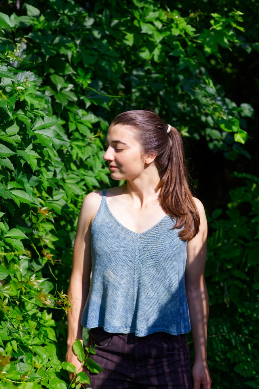 Shena is wearing Kiteborne, a bias-front v-neck knitted tank top with thin straps.