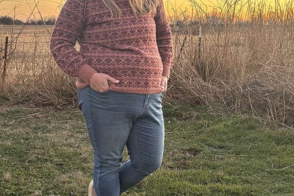 Allyson is wearing a fitted pink and black colourwork sweater.