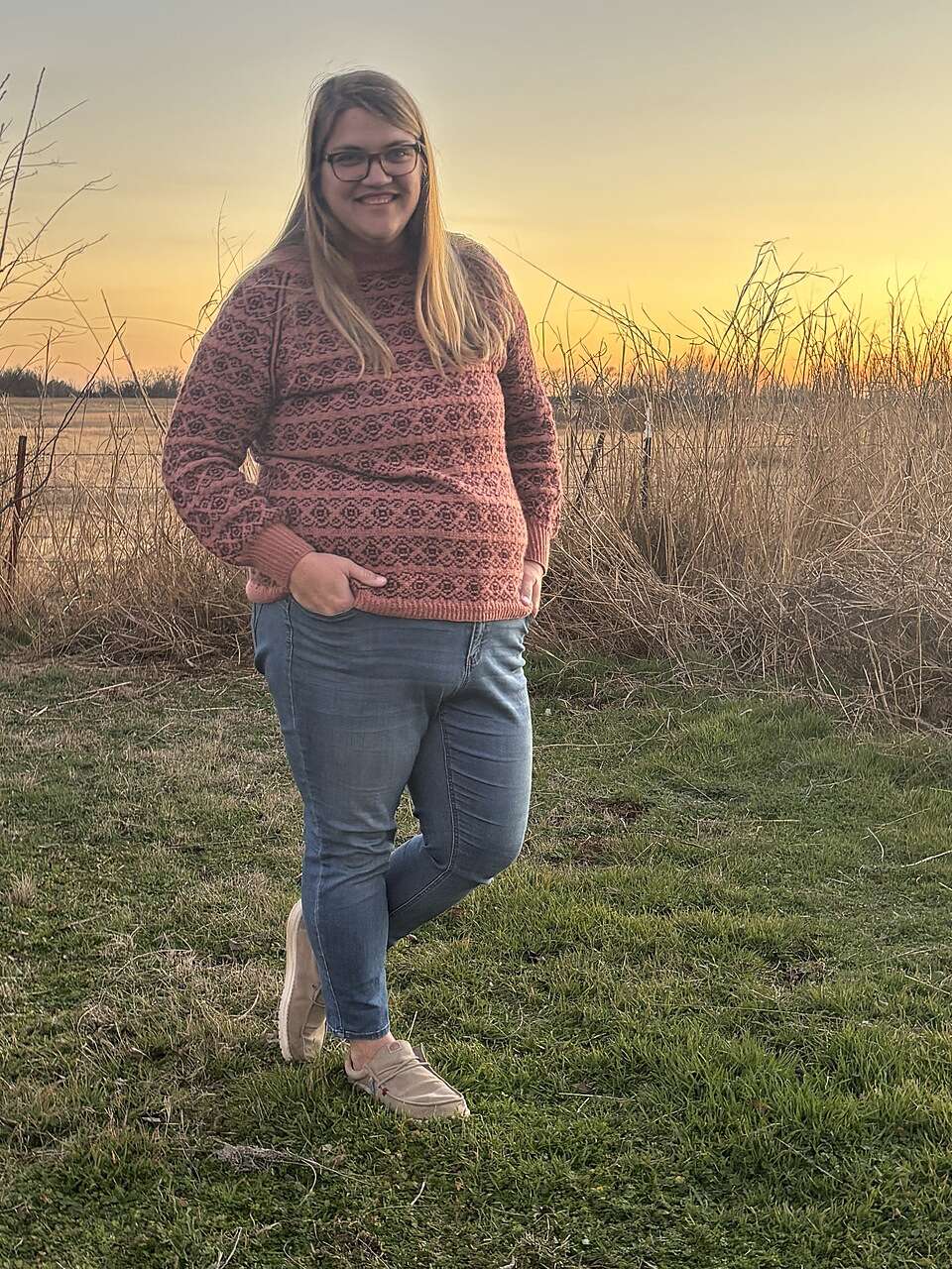 Allyson is wearing a fitted pink and black colourwork sweater.