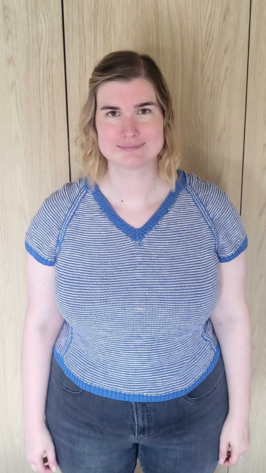 Andrea is wearing a blue and white Strawberry Strudel knitted tee with v neck.