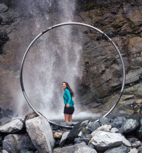 Jumping into the waterfall pool framed by a cyr wheel