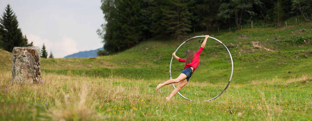 Looping with a cyr wheel a on mountain meadow