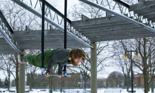 Guy doing the crocodile on a trapeze